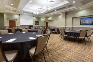 a conference room with tables and chairs and a screen at Drury Inn & Suites Cincinnati Sharonville in Sharonville