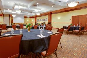 Drury Inn & Suites St. Louis Forest Park في سانت لويس: قاعة اجتماعات مع طاولة وكراسي كبيرة