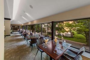 a dining room with tables and chairs and large windows at Sonesta White Plains Downtown in White Plains