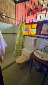 a bathroom with a toilet and a sink at Posada Turística Rocas De Cabo Marzo in Bahía Solano