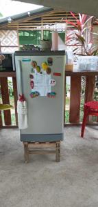 - un réfrigérateur avec des aimants devant une table dans l'établissement Lagkaw Dos in Lagkaw Homestay, à Looc