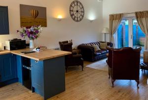 a kitchen and living room with a kitchen island and a living room at Rushcroft Farm Cottages in Sway