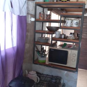 a microwave sitting on a shelf next to a stove at Hostal DOÑA EMMA in Florida +5 photos