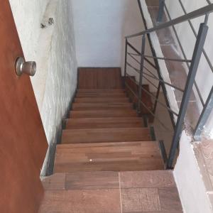 a wooden staircase with a metal railing and a door at Hostal DOÑA EMMA in Florida