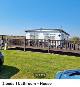 a house on a wooden deck with a house at Sunshine Lodge Haven Lakeland in Flookburgh
