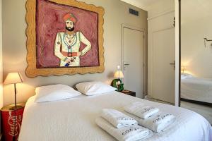 a bedroom with a bed with a painting on the wall at Superb 2 bedroom apartment with sea view on the Croisette in Cannes