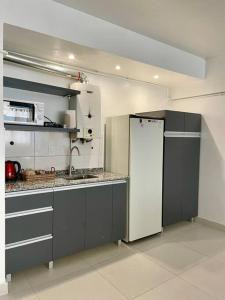 a kitchen with a white refrigerator in a room at Calido departamento en Mendoza in Mendoza