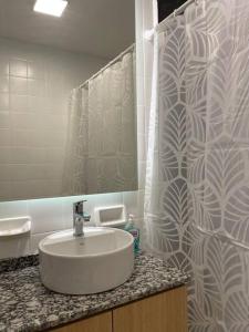 a bathroom with a sink and a shower curtain at Calido departamento en Mendoza in Mendoza
