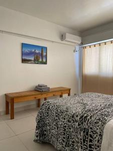 a bedroom with a bed and a wooden table at Calido departamento en Mendoza in Mendoza