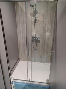 a man standing in a shower in a bathroom at Voyage Hostel - Rooms with Shared Kitchen in Douglas