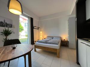 um quarto com uma cama e uma mesa em The East Apartment by Rabe - Netflix & Coffee & Parkplatz em Karlsruhe