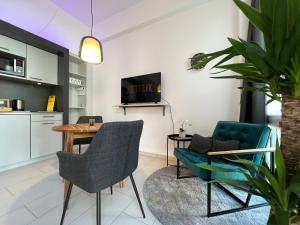 a living room with a table and chairs at The East Apartment by Rabe - Netflix & Coffee & Parkplatz in Karlsruhe