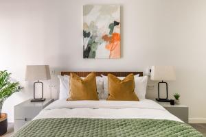 1 dormitorio con 1 cama con almohadas amarillas en Urban Rest Battersea Apartments, en Londres