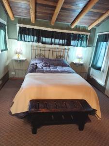 a bedroom with a large bed with a wooden headboard at Tres Coronas in San Martín de los Andes
