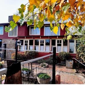 una casa roja con una valla delante en Tres Coronas en San Martín de los Andes