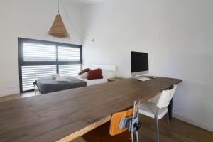 a room with a desk with a computer and a bed at Casa moderna y confortable en el corazón del Empordà in Colomés