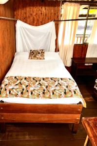 Cama en habitación de madera con cama sidx sidx sidx sidx en Posada Turística Rocas De Cabo Marzo, en Bahía Solano