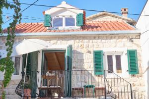 a house with green shutters and chairs on a balcony at Heritage House in Historic Center of Split in Split
