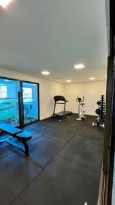 um ginásio com duas passadeiras e máquinas num quarto em Apartamento 2/4 no Francês em Marechal Deodoro