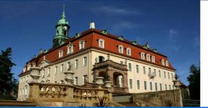 ein großes Gebäude mit einem Turm darüber in der Unterkunft Zum stillen Himmelbett in Niederwiesa