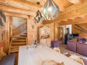 a log cabin living room with a dining table and stairs at Waldberg in Krimml
