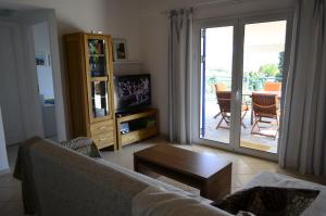 a living room with a couch and a sliding glass door at Villa Pilias in Methoni