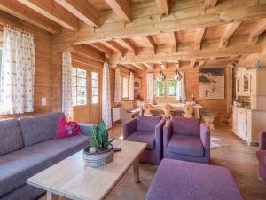 a living room with purple furniture in a log cabin at Windau in Krimml