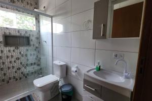 a bathroom with a toilet and a sink and a mirror at Residencial Mineiro- apartamento de 02 quartos in Itapoa