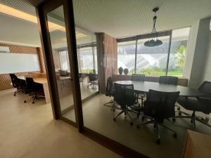 um escritório com uma sala de conferências com uma mesa e cadeiras em UNU Beach Class Ondina em Salvador