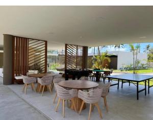 una sala da pranzo con tavoli e sedie e un patio di Makia Beach By BMS a Porto De Galinhas
