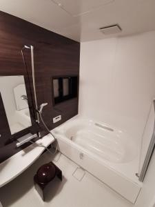 a white bathroom with a tub and a sink at Hida Takayamasan no machi House - Vacation STAY 98088v in Takayama