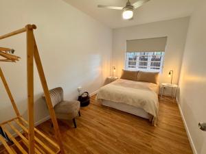 a bedroom with a bed and a chair and a window at 3 Bed Budget Accom Hidden Gem Parking Near Gabba in Brisbane