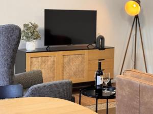 a living room with a television and a table with a bottle of wine at 3 Bed Budget Accom Hidden Gem Parking Near Gabba in Brisbane
