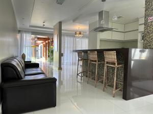 a kitchen with a bar and a couch and chairs at Casa da Jana com piscina in Porto Seguro