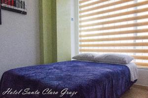 a bedroom with a blue bed with a window at Hotel Santa Clara Graze in Pasto