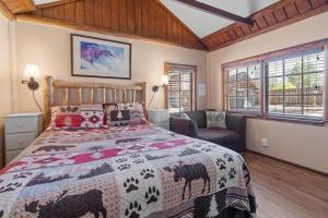 a bedroom with a bed and a couch and windows at Fox 'n Bear Cottages in Big Bear Lake