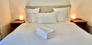 - un lit blanc avec deux lumières sur deux dans l'établissement Sunny, Spacious mountain views, Holiday home, à Lenah Valley