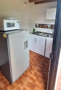 een keuken met een magnetron en een koelkast bij SA Cabaña cómoda y acogedora in San Agustín
