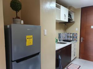 una cocina con nevera con un letrero amarillo. en Pico de Loro Staycation (3 beds- 6 pax) en Nasugbu
