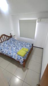 een klein bed in een kamer met een geel kussen erop bij DEPARTAMENTO 2 DORMITORIOS GODOY CRUZ MENDOZA in Godoy Cruz