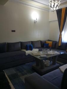 - un salon avec un canapé bleu et une table dans l'établissement إقامة النور, à Tanger