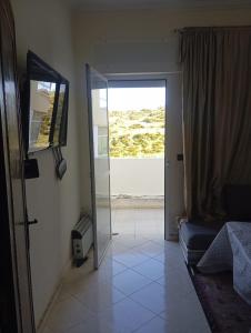 - un salon avec une porte en verre et un canapé dans l'établissement إقامة النور, à Tanger