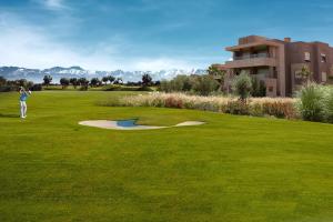 un hombre está jugando golf en un campo de golf en Prestigia,Golf, piscine, soleil, paysage, sport, spacieux,lux résidence en Marrakech