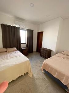 a bedroom with two beds and a window at San ber puerta del lago 4 dormitorios en suite in San Bernardino