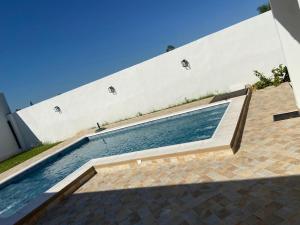 a swimming pool in front of a white building at San ber puerta del lago 4 dormitorios en suite in San Bernardino