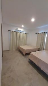 Zimmer mit 2 Betten und Vorhängen in der Unterkunft San ber puerta del lago 4 dormitorios en suite in San Bernardino