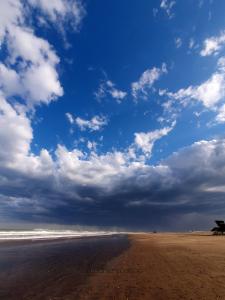uma praia com um céu nublado e o oceano em Casa a estrenar en Mar del Plata proximo a Mogotes, a las playas del sur y cerca del Faro em Mar del Plata
