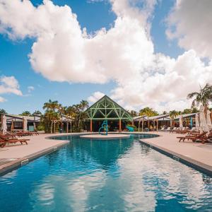 uma piscina num resort com cadeiras e um pavilhão em Karukera lodge , Résidence Blue Dream em Grand-Bourg