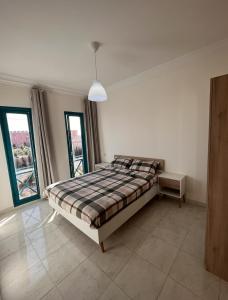 ein Schlafzimmer mit einem Bett in einem Zimmer mit Fenstern in der Unterkunft Spacious 3-Floor Riad in Marrakesch