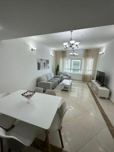een woonkamer met een witte tafel en een bank bij Smart Home Vacation Home- AYLA in Sharjah